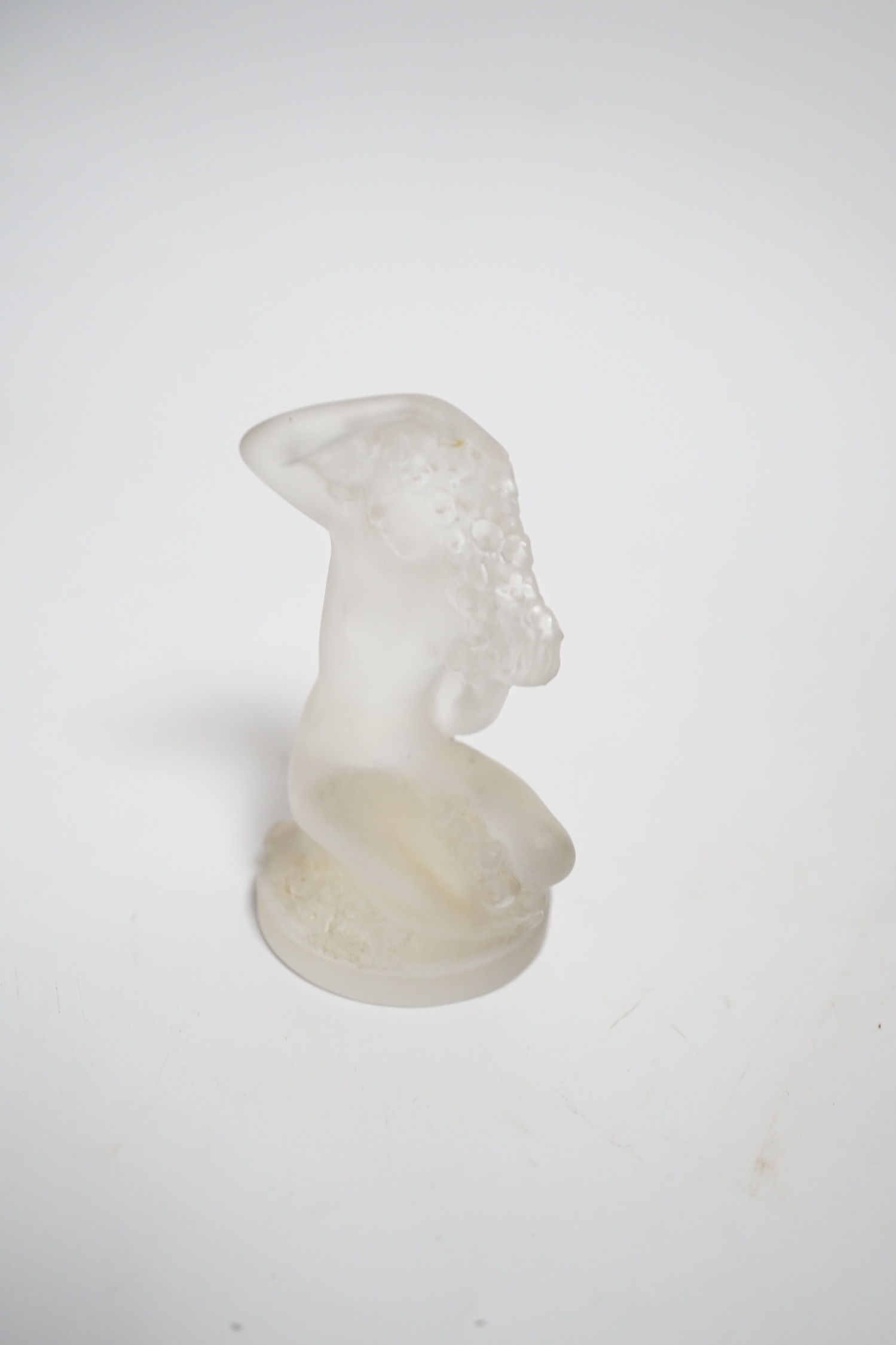 A Lalique glass figure of a kneeling female, signed, 8cm high